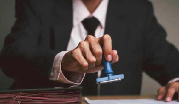 Prestige Electronic City Approvals — RERA Registration Status Awaited Document being officially stamped, representing RERA registration and statutory approval processes for a residential project